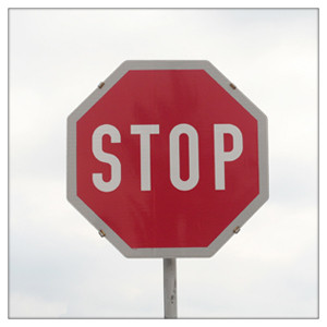 Ein Stoppschild mit wolkigem Himmel im Hintergrund.