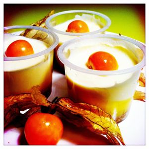 Drei Becher gefüllt mit cremigem Dessert, oben drauf liegt eine Kapstachelbeere.