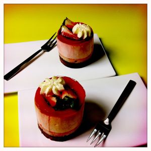 Auf zwei kleinen Tellern sind je ein sahniges Dessert mit Beeren als Topping zu sehen.
