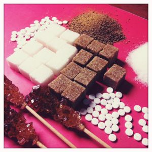 Was bewirkt Aspartam? Auf dem Bild sind verschiedene Zuckerarten und Süßstoffe zu sehen.